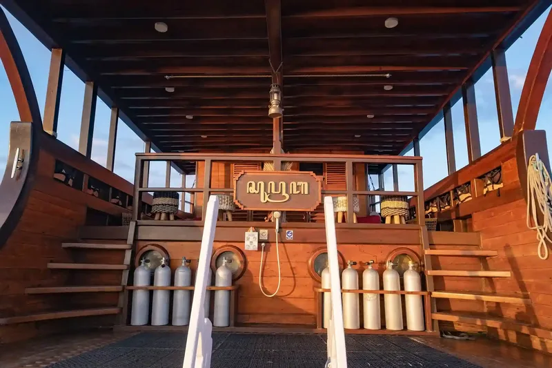 Scuba tanks lined up on a liveaboard dive deck in Komodo