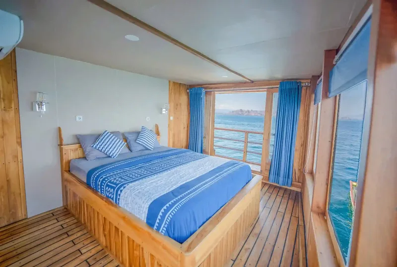 A timber cabin with twin beds aboard a deluxe liveaboard phinisi