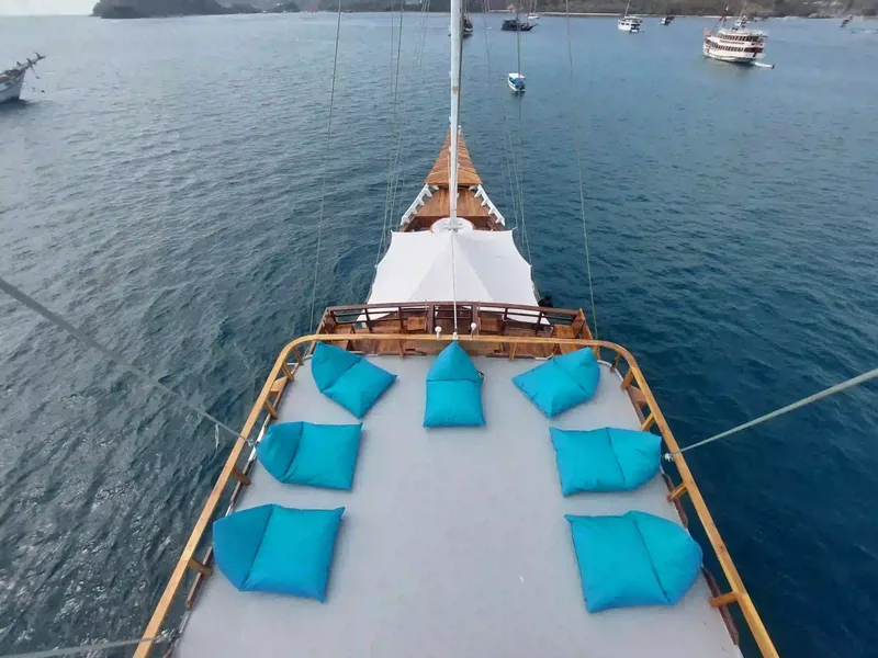 Turquoise cushions laid out on the foredeck of a Komodo liveaboard