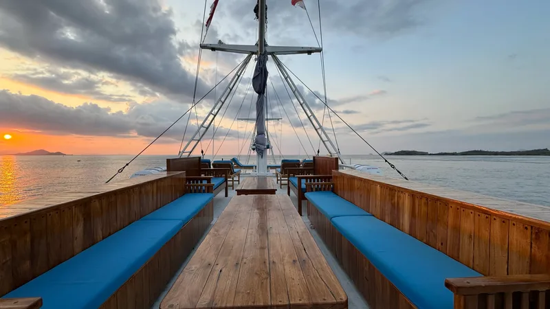The open deck of a charter boat at sunset in Komodo