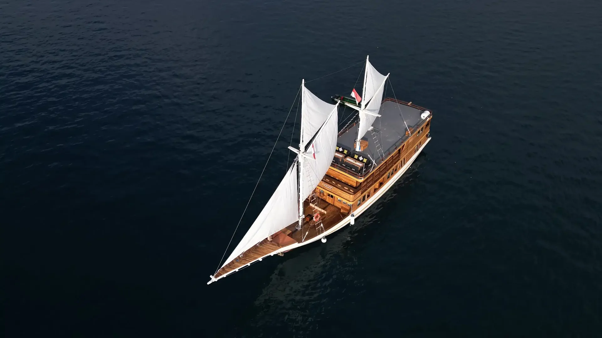 A phinisi under sail on open water in Komodo National Park