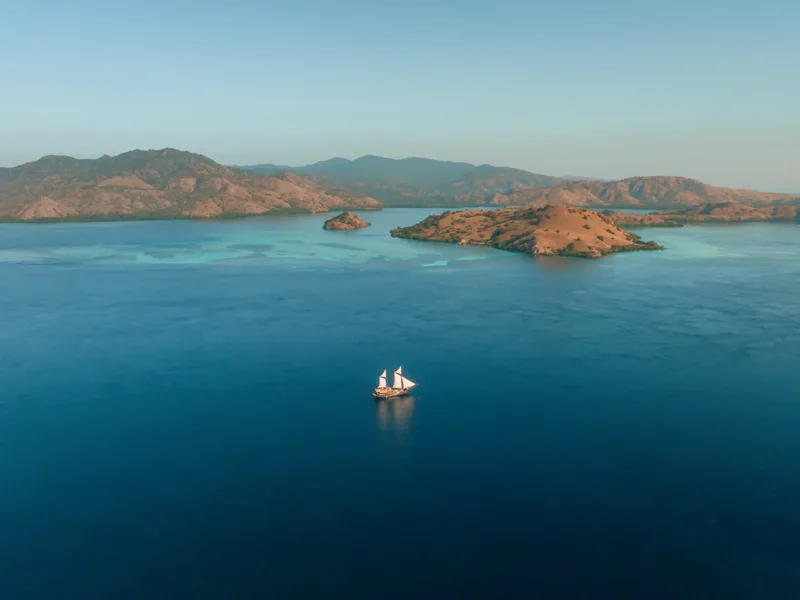 A traditional phinisi under sail in Komodo National Park